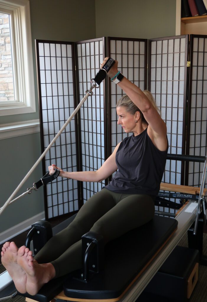 Pilates reformer teacher training and demonstrating with a machine