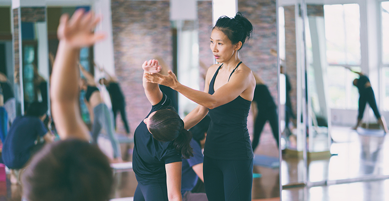 Group women doing stretching yoga hot exercises with instr