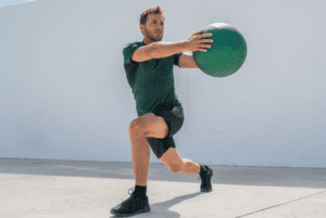 Man using large green medicine ball as a part of his corrective exercise efforts.