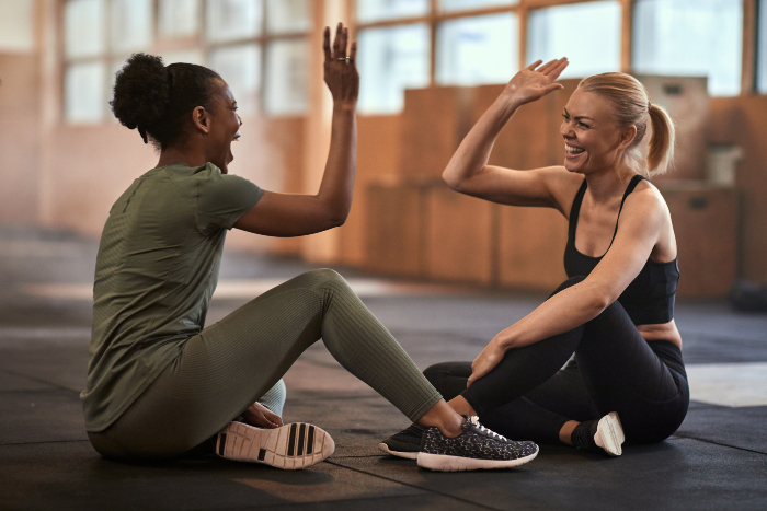 women giving each other a high five after wellness coach certification renewal